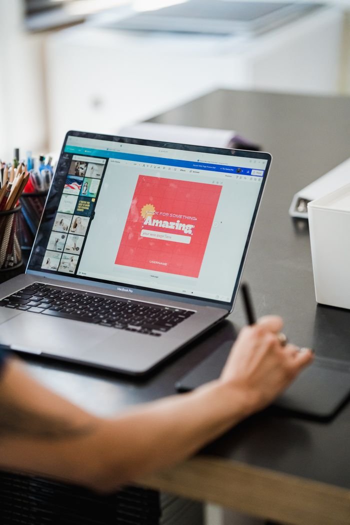 The Art of Drawing Readers In: Your attractive post title goes here Person using a laptop and graphic tablet for digital design work in a home office.